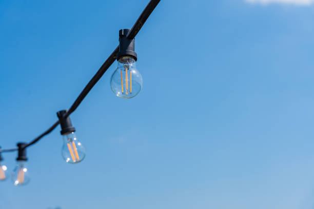 istock Light bulbs against a background of clear blue sky on a sunny day 2160102079
