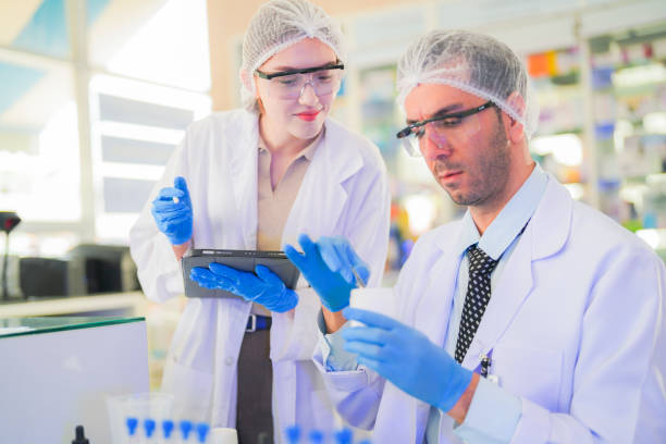 istock scientists perform experiments and record data. people arranges equipment with test tubes and chemicals for producing medicine and biochemistry. man hold tubes of chemical liquids and plant samples. 2160103469