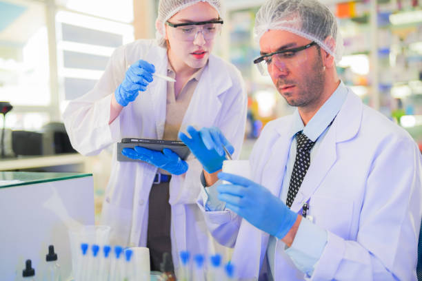 istock scientists perform experiments and record data. people arranges equipment with test tubes and chemicals for producing medicine and biochemistry. man hold tubes of chemical liquids and plant samples. 2160103481