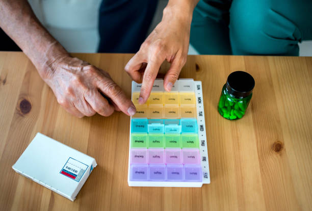 Home nurse helps senior patient organize medication