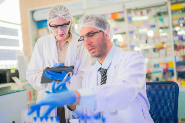 istock scientists perform experiments and record data. people arranges equipment with test tubes and chemicals for producing medicine and biochemistry. man hold tubes of chemical liquids and plant samples. 2160104828
