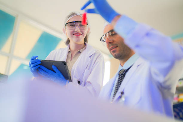 istock scientists perform experiments and record data. people arranges equipment with test tubes and chemicals for producing medicine and biochemistry. man hold tubes of chemical liquids and plant samples. 2160105059