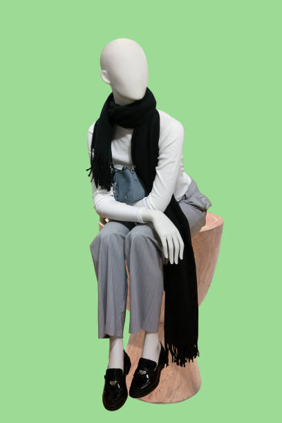 Full length image of a female display sitting mannequin isolated on green background