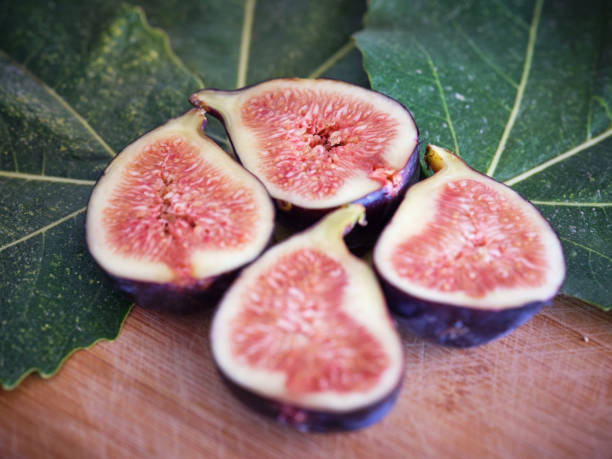 istock Halved figs near green leaves 2160106264