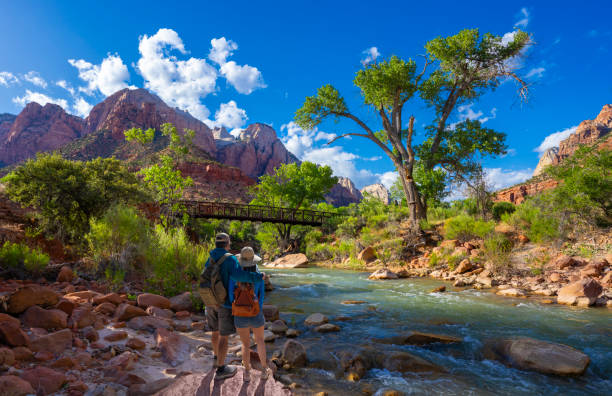 Couple relaxing by the river on hiking trip in Utah stock photo