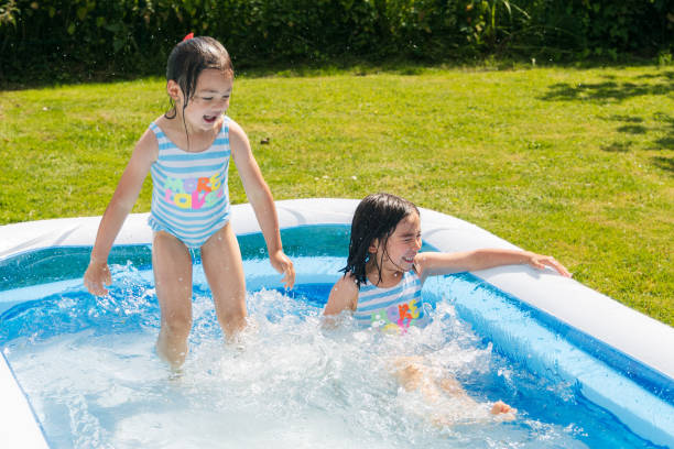 istock Kids Playing with Hose and Swimming Pool 2160107664