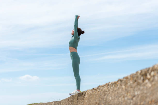istock Sporty woman doing arm stretching exercise outdoors against a blue sky. warm up exercises. 2160110164