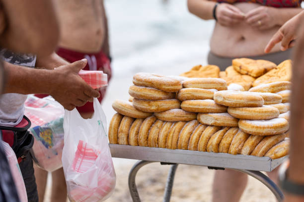 istock Unrecognizable people, buying doughnuts from the vendor at the beach 2160111659