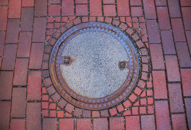istock Manhole on the red paving stone road 2160112610