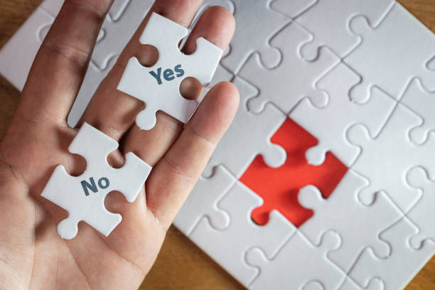istock A hand holding two puzzle pieces trying to decide 2160118663