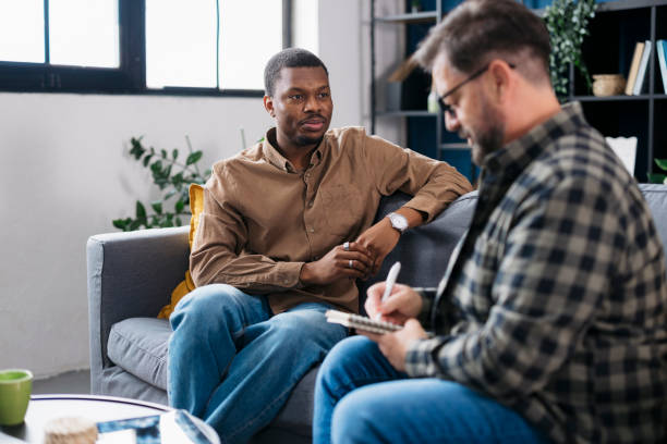 istock Young man sharing his problems with therapist during psychotherapy session in office 2160120376