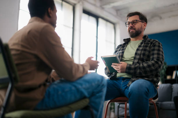 istock Psychologist taking notes on his patient at therapy session 2160120872