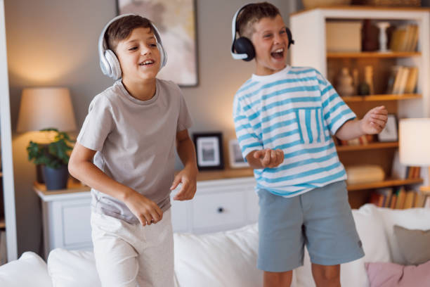 istock Two boys dancing with headphones, filled with joy 2160125509