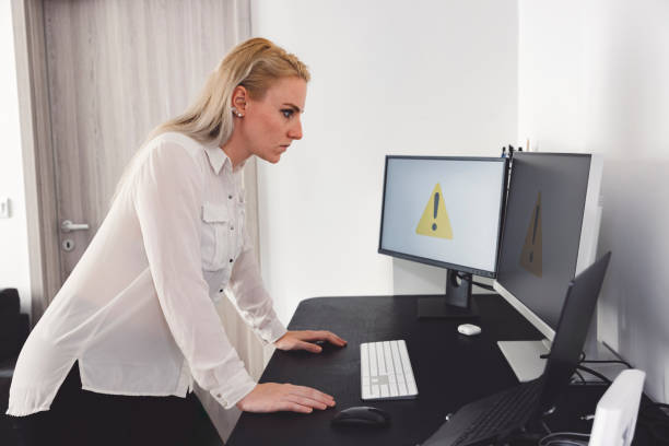 istock Person frustrated with computer warning symbols on monitors 2160126873