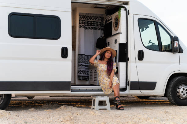 istock Latin woman sitting on motor home 2160127366