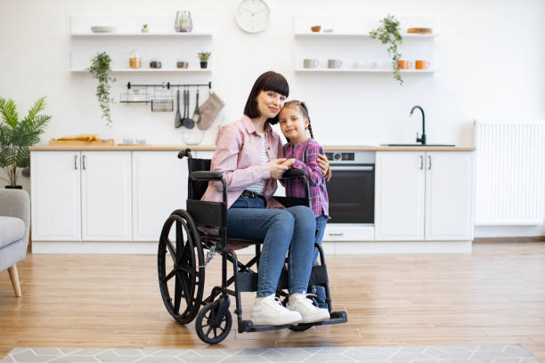 istock Mother in wheelchair hugging daughter in bright kitchen 2160132171