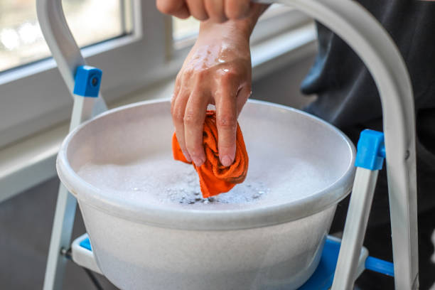istock Spring cleaning. Woman washing windows with liquid detergent solution and a rag 2160135684