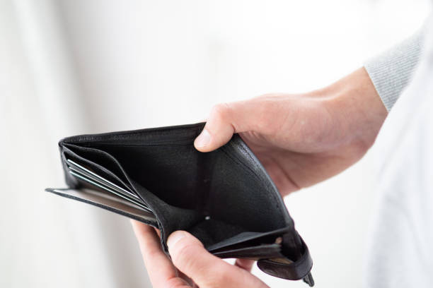 istock A man holding empty wallet close up, hands of poor man open empty purse 2160140646