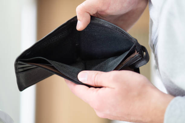 istock A man holding empty wallet close up, hands of poor man open empty purse 2160140707