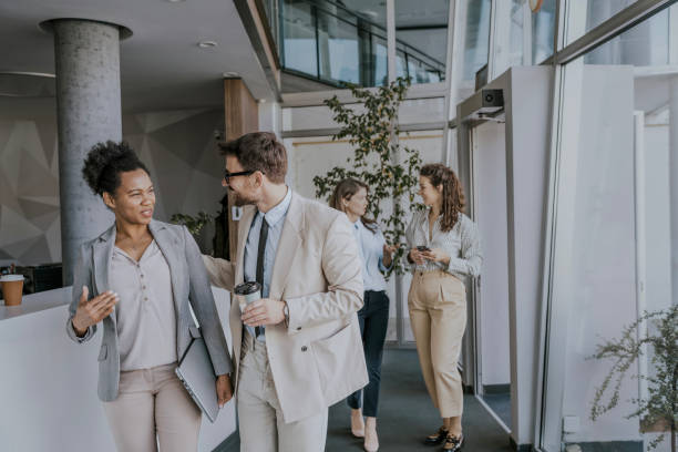 istock Business colleagues chatting in modern office building lobby 2160144553