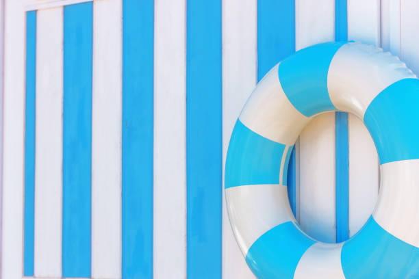 istock blue and white inflatable ring on striped wall, beach and pool safety, summertime background 2160144589