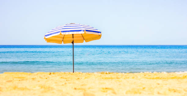 istock umbrella on beach, no people, summer sea background 2160144652