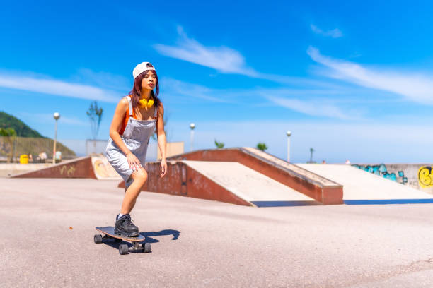 istock Cool asian skater practicing in an urban skateboard park 2160145267