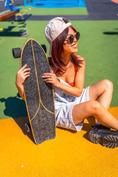 istock Modern young woman with skateboard in a park 2160147788