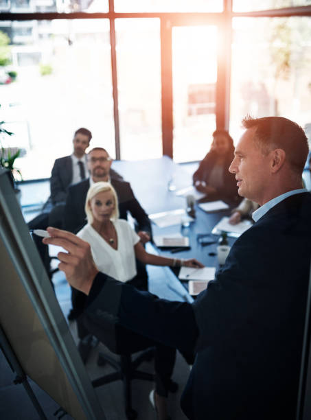 istock Business people, presentation and man with brainstorming, coaching and feedback with proposal. Group, employees and mentor with information, meeting and planning with vision for company and teamwork 2160150875