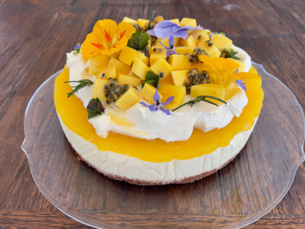 istock Mango cheesecake topped with cream, fresh fruit and colourful flowers 2160151054