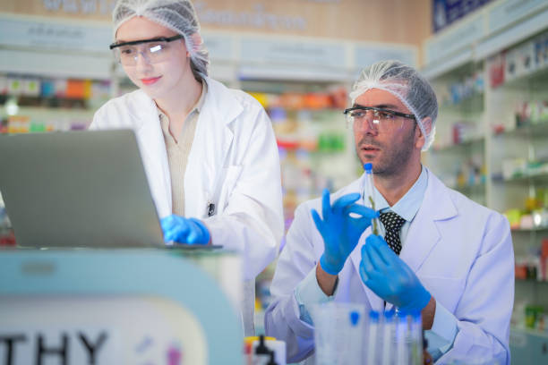 istock scientists perform experiments and record data. people arranges equipment with test tubes and chemicals for producing medicine and biochemistry. man hold tubes of chemical liquids and plant samples. 2160151067