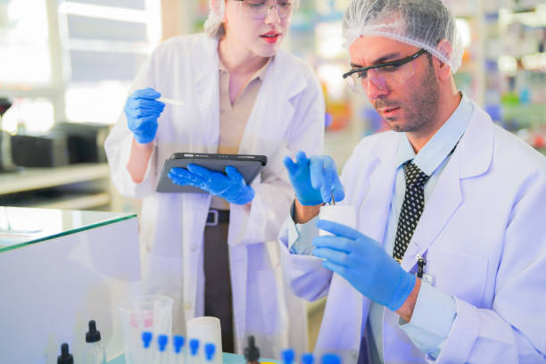 istock scientists perform experiments and record data. people arranges equipment with test tubes and chemicals for producing medicine and biochemistry. man hold tubes of chemical liquids and plant samples. 2160151210