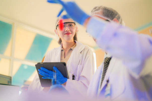 istock scientists perform experiments and record data. people arranges equipment with test tubes and chemicals for producing medicine and biochemistry. man hold tubes of chemical liquids and plant samples. 2160151487