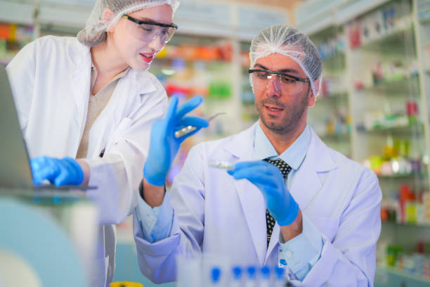 istock scientists perform experiments and record data. people arranges equipment with test tubes and chemicals for producing medicine and biochemistry. man hold tubes of chemical liquids and plant samples. 2160152140