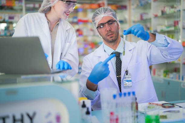 istock scientists perform experiments and record data. people arranges equipment with test tubes and chemicals for producing medicine and biochemistry. man hold tubes of chemical liquids and plant samples. 2160152641