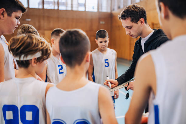 istock Coach discusses strategy with youth basketball team 2160153325