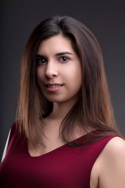 istock Brunette woman with long hair smiling on grey background 2160155155