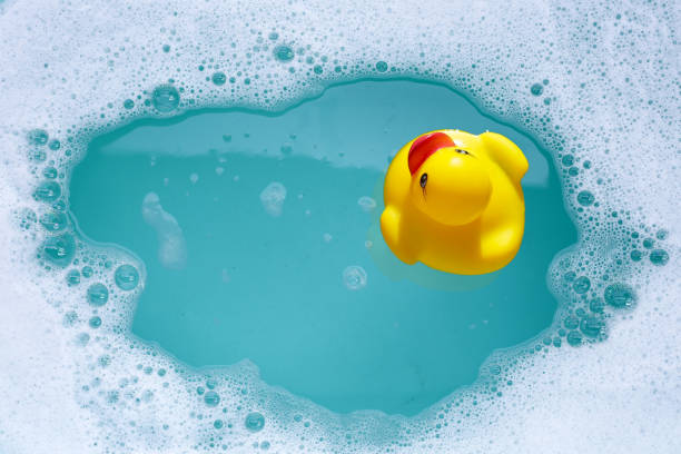 istock Yellow rubber duck in water with soap foam 2160158855