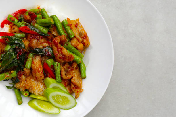 Rice topped with stir fried pork and red curry paste with yard-long bean