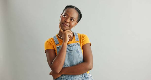 istock Black girl, studio and thinking of ideas for problem solving or planning, insight and brainstorming for decision. Woman, thoughtful and isolated on white background with mockup, pensive and choice. 2160159870