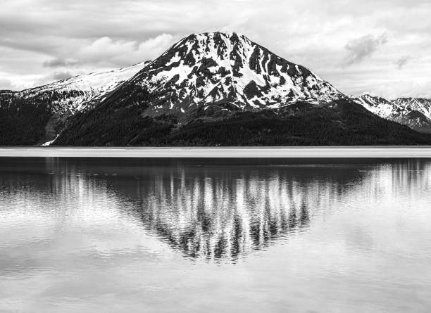 Snowy mountain reflects in the water black and white