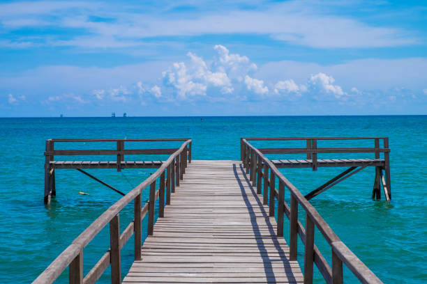 A wooden pier with beautiful ocean views and blue sky in the background