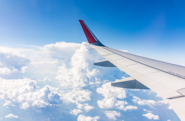 istock View from the airplane window at a beautiful cloudy sky and the airplane wing 2160176836