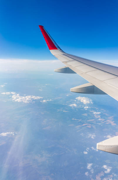 istock View from the airplane window at a beautiful cloudy sky and the airplane wing 2160176846