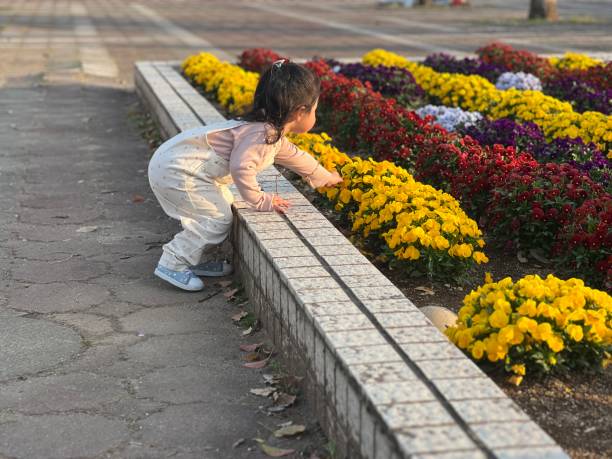 Girl playing with spring flowers in the park