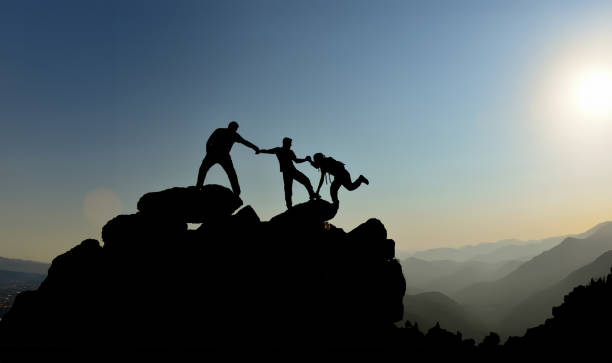 istock Three climbers support each other by making their final push to reach the summit. 2160180589