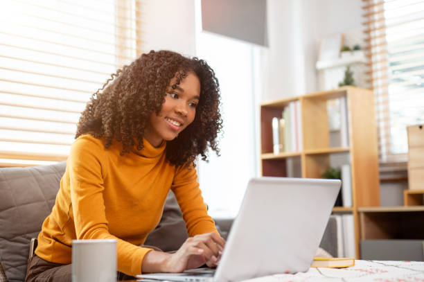 istock A beautiful, positive Black woman is responding to emails on her laptop computer, working from home. 2160182442