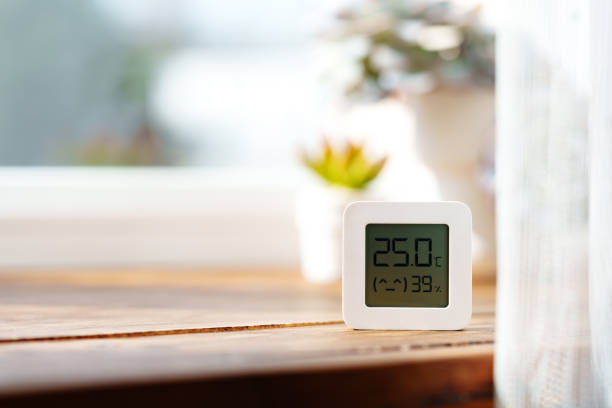 istock Digital Thermometer Displaying Temperature and Humidity Near Window 2160183129