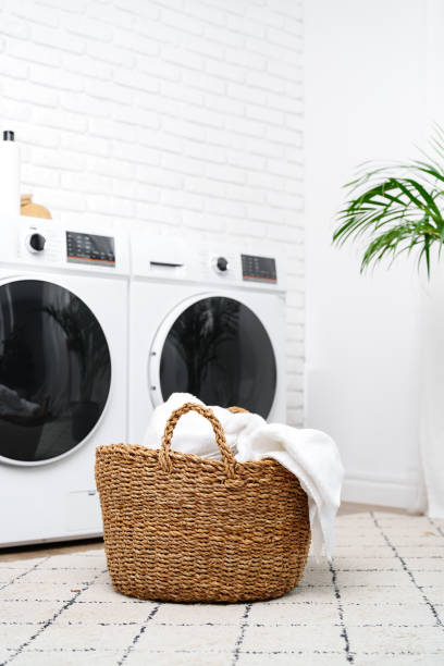 istock Laundry Basket With White Towels Near Modern Washers In A Modern Home 2160183964