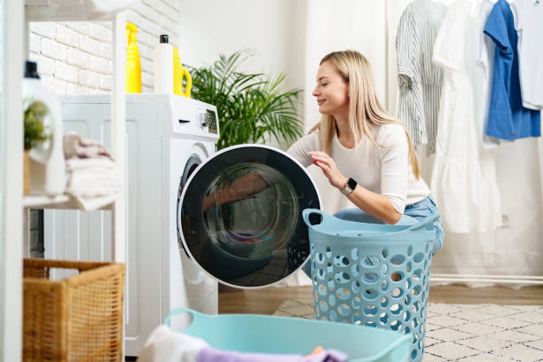 istock Woman Doing Laundry near a Washing Machine 2160185345